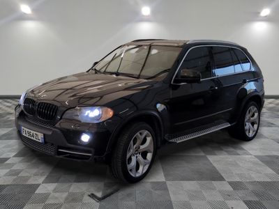 a picture of a black bmw suv parked in a garage