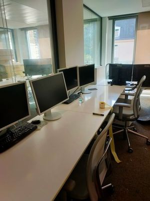 trois ordinateurs posés sur le bureau dans le bureau