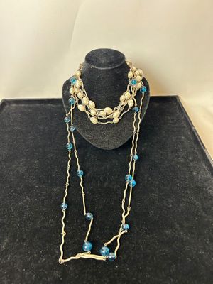a close up of a necklace on a mannequin with blue beads