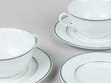 three pieces of white and green dinnerware on a table
