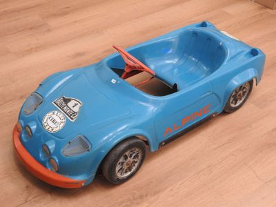 une petite voiture posée sur un parquet