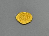 a close up of a gold coin on a gray surface