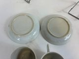 two cups and a saucer sitting on a table
