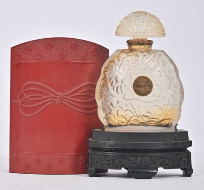 un flacon de parfum posé à côté d'une boîte rouge