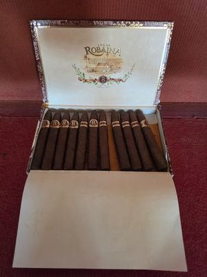un gros plan sur une boîte de cigares posée sur un tapis rouge