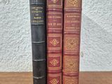 three old books sitting on top of a wooden table next to each other