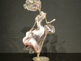 une figurine en verre représentant une femme assise sur une chaise