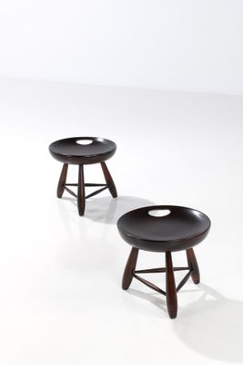 deux petits tabourets avec des pieds en bois et un assise noire