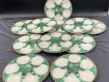 a set of six green and white plates on a table