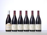 six bottles of wine lined up in a row on a table