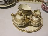 une table blanche sur laquelle sont disposées des assiettes, des tasses et des soucoupes