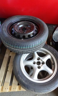 les pneus et les jantes sont empilés sur des palettes dans un garage