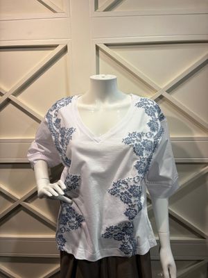 un mannequin portant une chemise blanche ornée de fleurs bleues