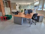a desk with two computers and a chair in a room