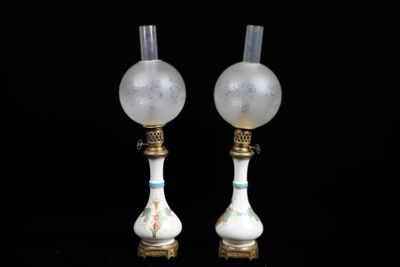 pair of white glass lamps with gold trims on a black background
