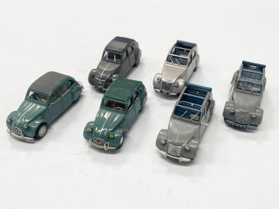 plusieurs petites voitures sont alignées sur une surface blanche