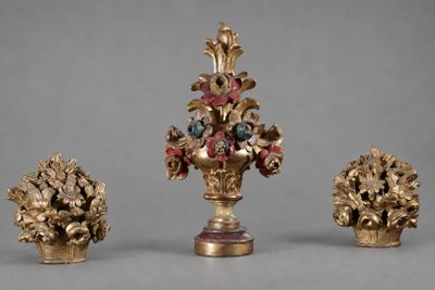 trois vases, chacun contenant des fleurs, posés sur une table