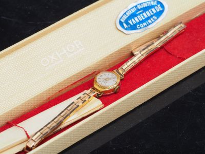 a pen and a watch in a box on a table