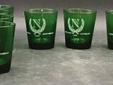 many green shot glasses lined up on the counter