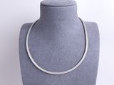 a silver necklace on a mannequin display with a white background