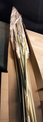 un couteau posé sur une table à côté d'un bouquet d'herbe