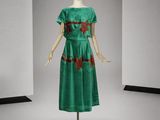 une photo d'un mannequin portant une robe verte ornée de fleurs rouges