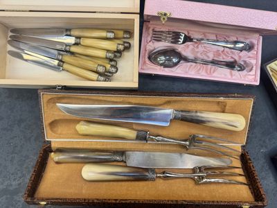 a lot of different types of knives and spoons in a box