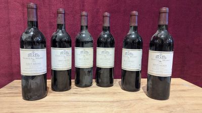 six bottles of red wine are lined up on a wooden table