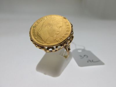 a close up of a gold ring with a coin on it