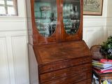 a wooden cabinet with a glass door in a room