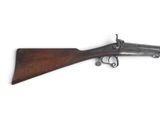 un vieux fusil avec une poignée en bois sur fond blanc