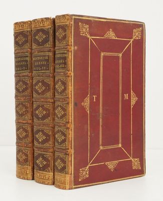 two old books sitting on top of each other on a white surface