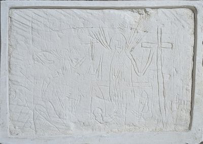 a white relief of a man on a cross on a wall