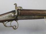 a close up of a gun on display on a white surface