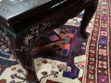 a black table with a floral design on it on a rug