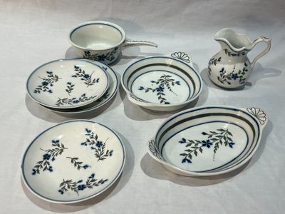 plusieurs pièces de vaisselle bleue et blanche et un pichet posés sur une table