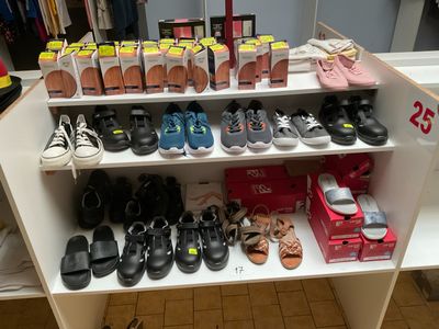 de nombreuses paires de chaussures sur une étagère dans un magasin de chaussures