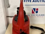 an orange fire hydrant sitting on top of a table next to a sign