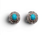 une paire de boucles d'oreilles en turquoise et diamants sur fond blanc