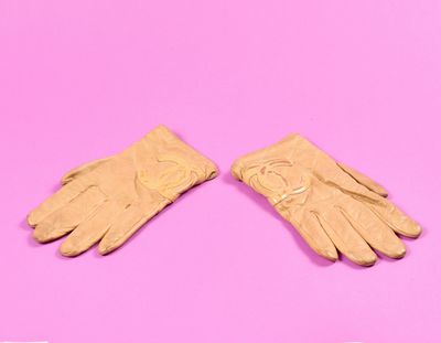 une paire de gants en cuir beige sur fond rose