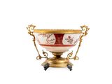 un bol richement décoré, doré et rouge, posé sur un socle, sur fond blanc