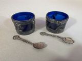two cups and spoons sitting on a table