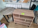 une petite table sur laquelle se trouve une étagère à livres et une petite table sur laquelle se trouve un livre