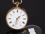 an antique pocket watch sitting on top of a black surface