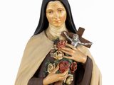 statue of a woman with a cross and roses in her hands