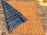 a close up of a blue and orange blanket on a stone floor