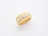 gros plan d'une bague en or sur une surface blanche