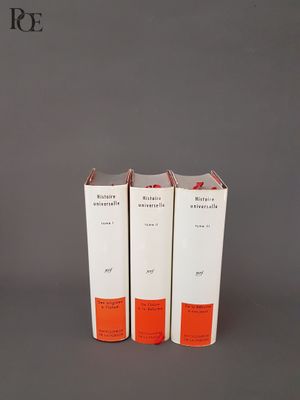 trois livres sont empilés sur une surface grise