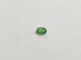a close up of a green gemstone on a white surface