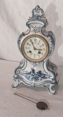 une petite horloge bleue et blanche posée sur une table